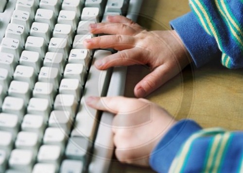Kinderhaende auf Computertastatur