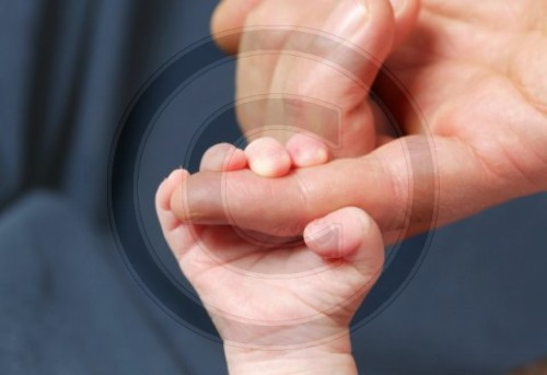Baby haelt sich am Finger fest