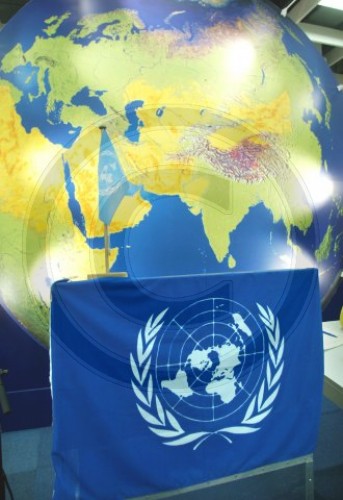 UN - Flagge vor einer Weltkarte