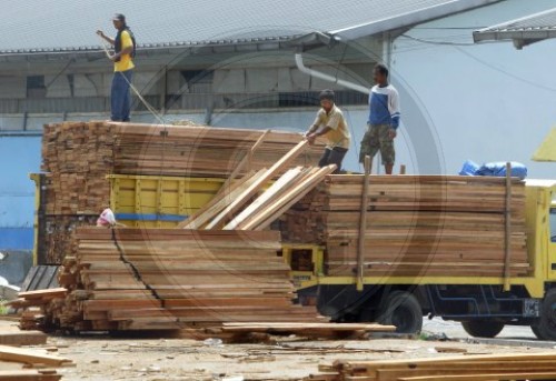 Im Hafen von Jakarat werden Tropenhoelzer entladen