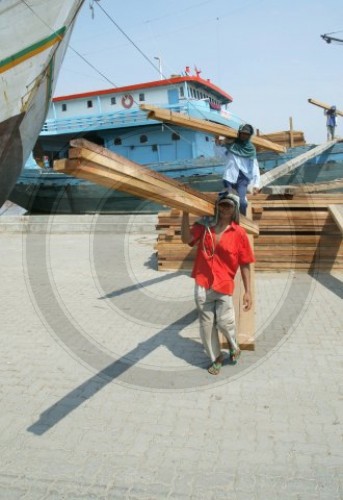 Im Hafen von Jakarat werden Tropenhoelzer entladen