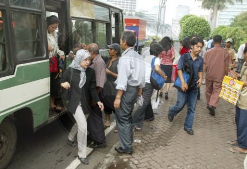 Fahrgaeste verlassen einen oeffentlichen Bus