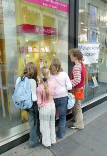 Kinder vor einem Schaufenster einer T-Punkt Geschaeftstelle