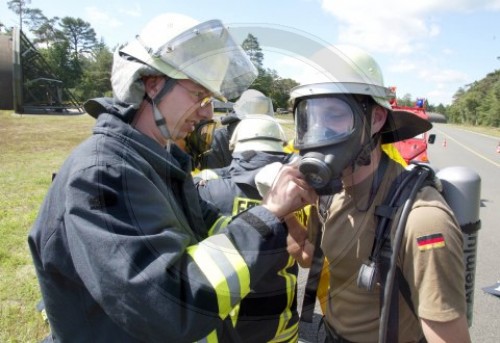 Soldaten der Feuerwehr beim Anlegen von Atemschutzgeraet