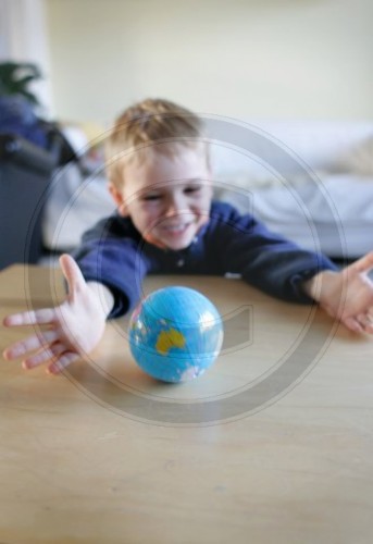 Junge spielt mit Weltkugel
