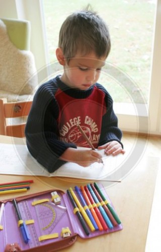 Junge malt mit Buntstiften