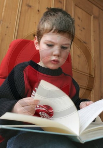 Junge liest in einem Buch