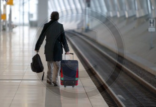 Reisende mit Gepaeck geht ueber einen Bahnsteig