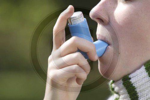 Junge Frau nimmt ein Asthmaspray