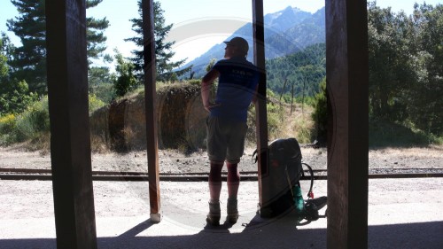 Wanderer mit Rucksack am Bahnhof