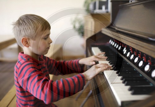 Junge spielt Harmonium