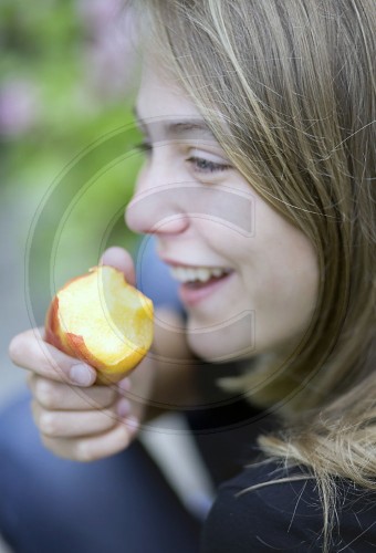 Maedchen isst eine Nektarine