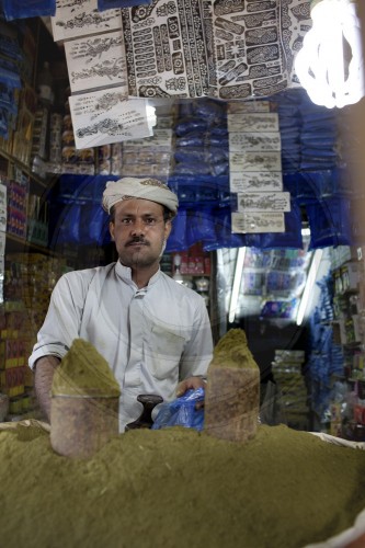 Kat kauender Hennahaendler in der Altstadt von Sanaa