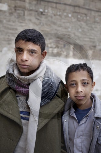 Kat kauende Jugendliche in der Altstadt von Sanaa