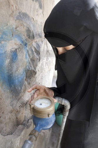 Frauen liest der Altstadt von Sanaa eine Wasseruhr ab