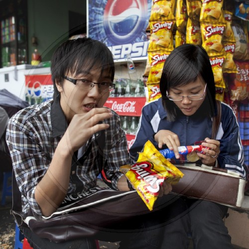 Junge Vietnamesen in einem Strassencafe| Young Vietnamese people in a street cafe