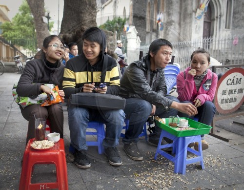 Junge Vietnamesen in einem Strassencafe| Young Vietnamese people in a street cafe