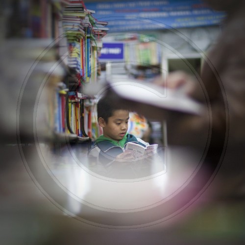 Junge liest in einem Buchladen| Boy reading in a bookstore