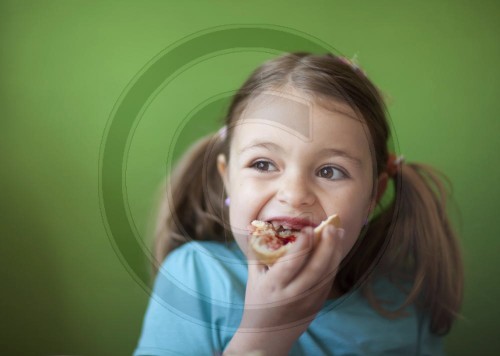 Maedchen isst ein Broetchen | Girl eating a bread roll