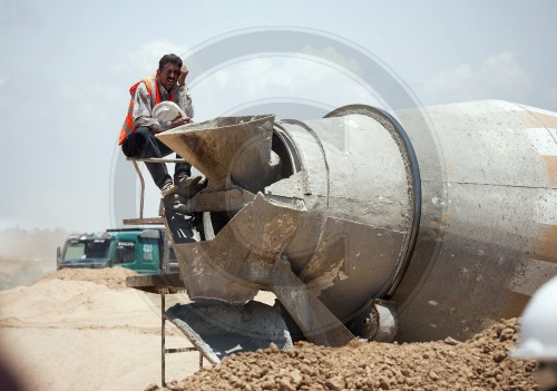 A worker at a cement mixer at the construction site of a sludge drying facility in East Burei / Palestinian Territories. 14.06.2011