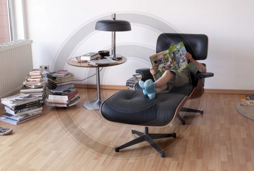 Junge liest in einem Sessel|Boy reading in an armchair