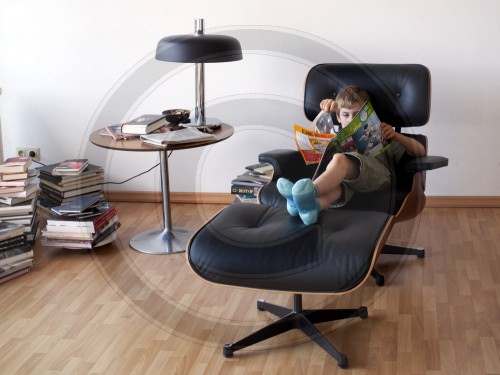 Junge liest in einem Sessel|Boy reading in an armchair