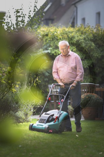 Rentner beim Rasenmaehen