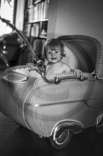 Kind in einem Kinderwagen aus den 50er Jahren.