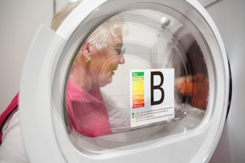 Seniorin belaedt eine Waschmaschine der Effizienzklasse B