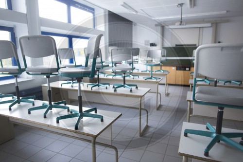 Aufgestellte Stuehle in einem leeren Klassenzimmer