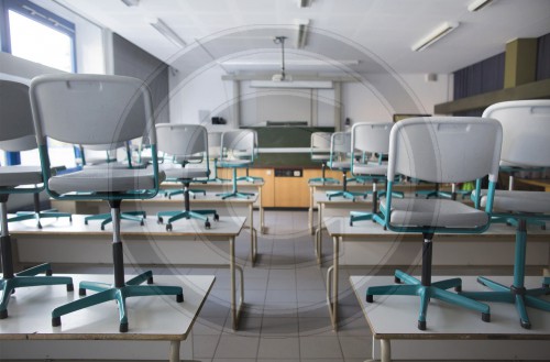 Aufgestellte Stuehle in einem leeren Klassenzimmer