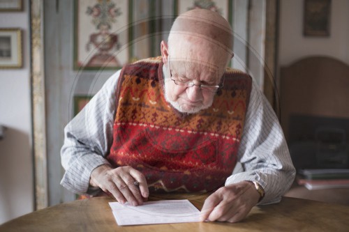 Rentner beim Ausfuellen eines Formulars