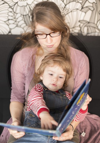 Junge Mutter liest ihrem Kind ein Buch vor