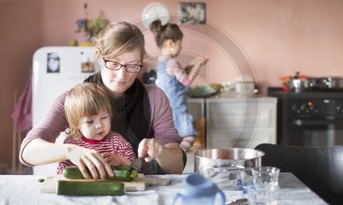 Junge Mutter kocht mit ihren Kindern