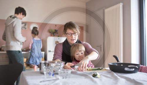 Junge Familie kocht gesundes Essen