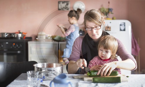 Junge Mutter kocht mit ihren Kindern