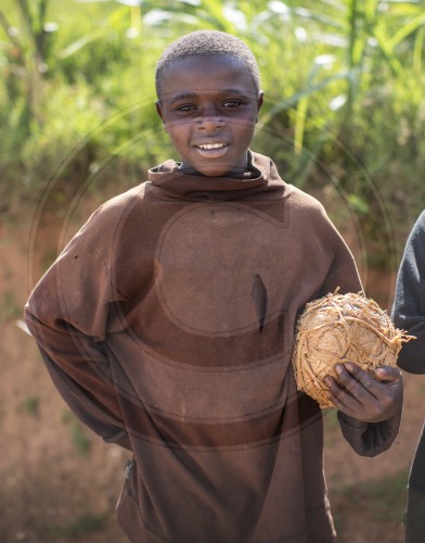 Afrkanischer Junge mit einem Strohfussball