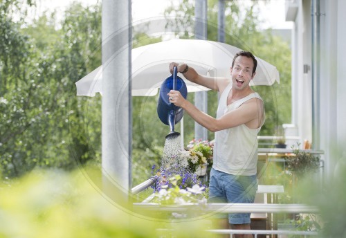 Junger Mann auf seinem Balkon