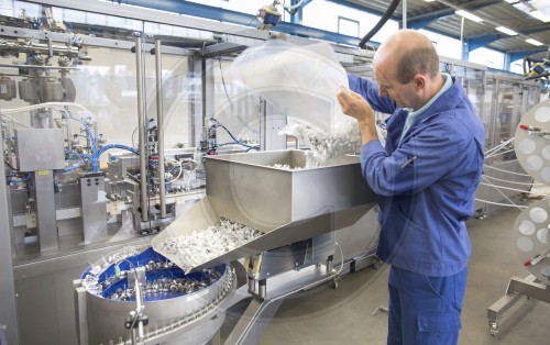 Techniker an einer Maschine zur Produktion von Infusionsbeuteln fuer die Pharmaindustrie