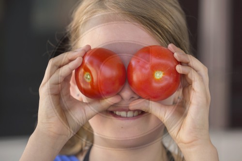 Kind mit Tomaten