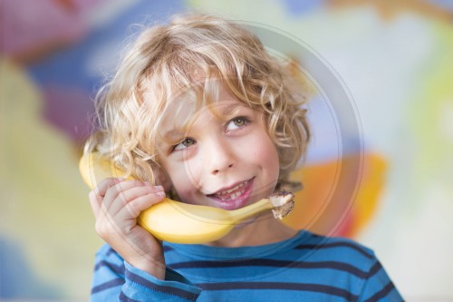 Portrait von einem Sechsjaehrigen mit einem Bananentelefon