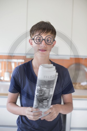 Junge mit Brille und Zeitung