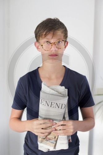 Junge mit Brille und Zeitung