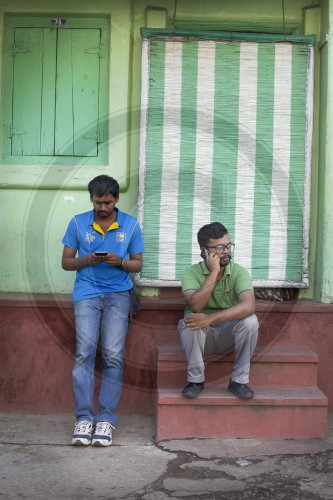 Junge Maenner mit Handys in Sri Lanka