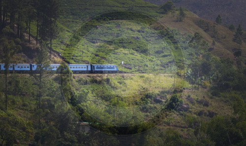 Blauer Zug in gruenen Bergen