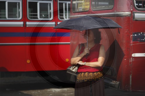 Frau wartet auf einen Bus in Sri Lanka