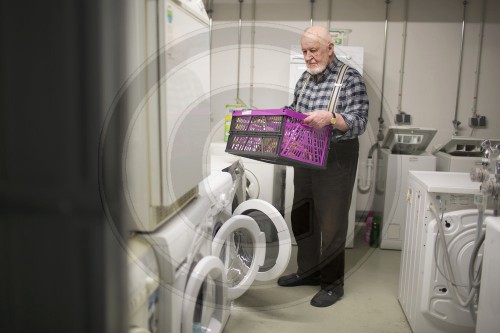 Alter Mann an der Waschmaschine