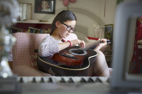 Zwoelf jaehriges Maedchen spielt Guitarre