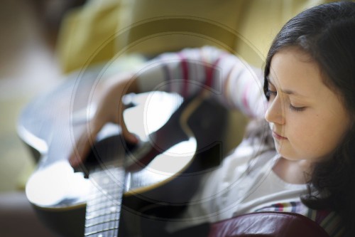 Neun jaehriges Maedchen spielt Guitarre