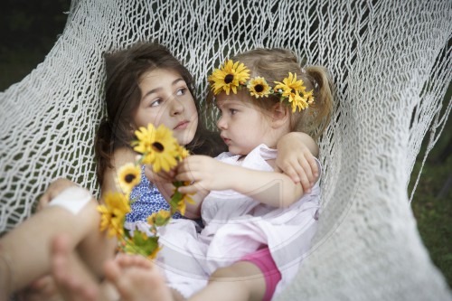 Kinder im Sommerkleid in einer Haengematte